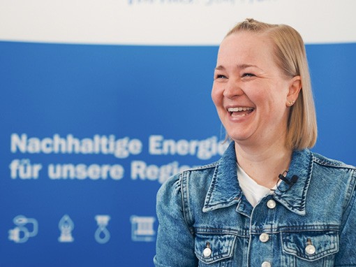 Eine Mitarbeiterin der TEN eG mit blonden mittellangen Haaren lächelt glücklich.