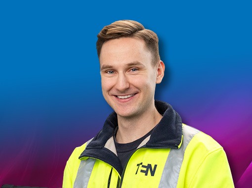 Mitarbeiter der TEN eG in leuchtend gelber Arbeitsjacke lächelt.