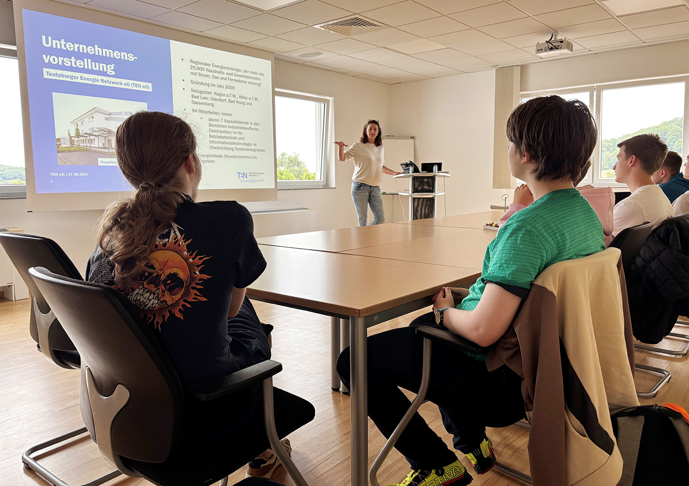 Eine Frau zeigt sechs Schülern der 9. Klasse eine Power Point Präsentation. Die Schüler sitzen an Tischen und schauen auf die Leinwand.