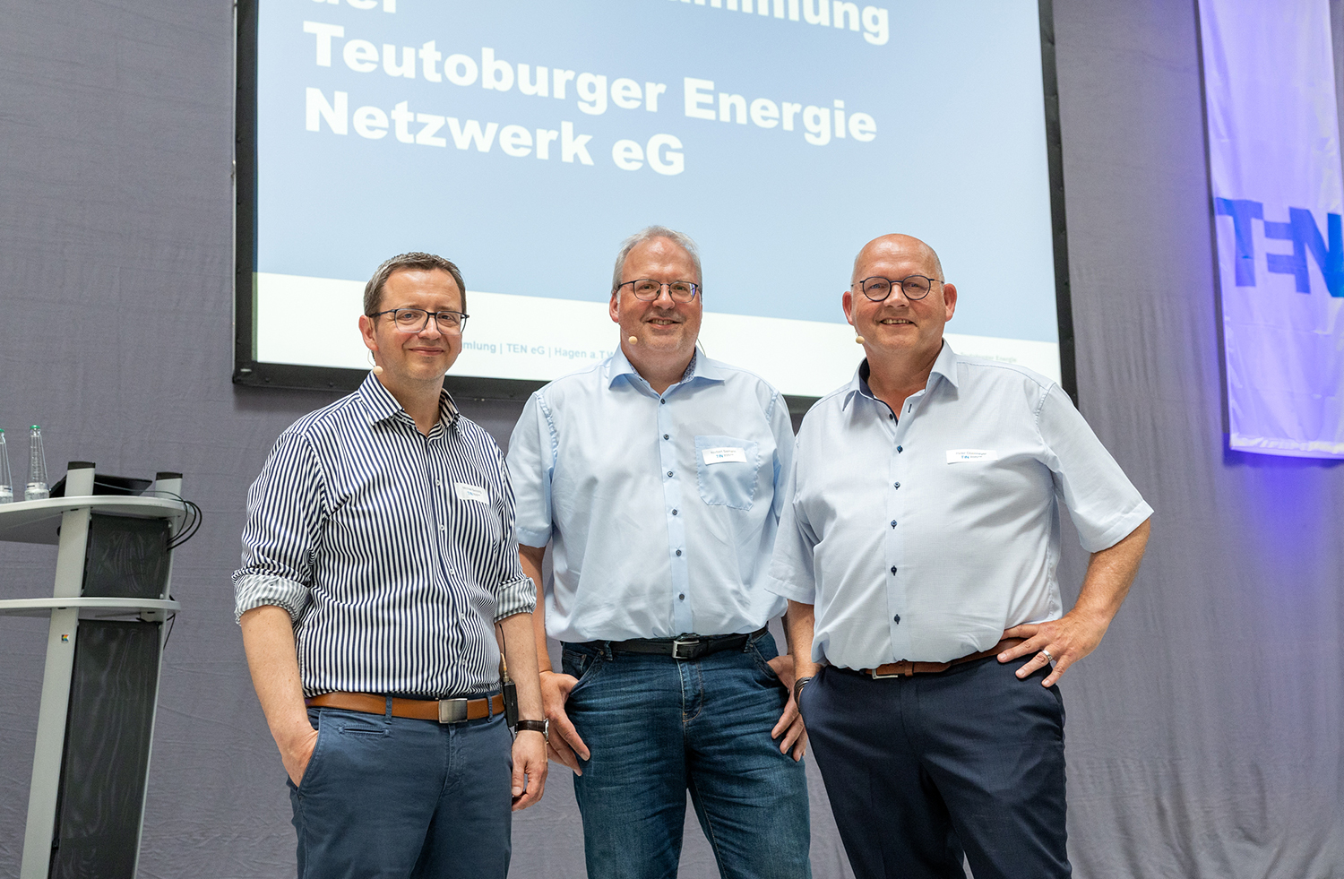 Anlässlich der Generalversammlung stehen die 2 Vorstände und der Aufsichtsratsvorsitzende zusammen und posieren fürs Foto.